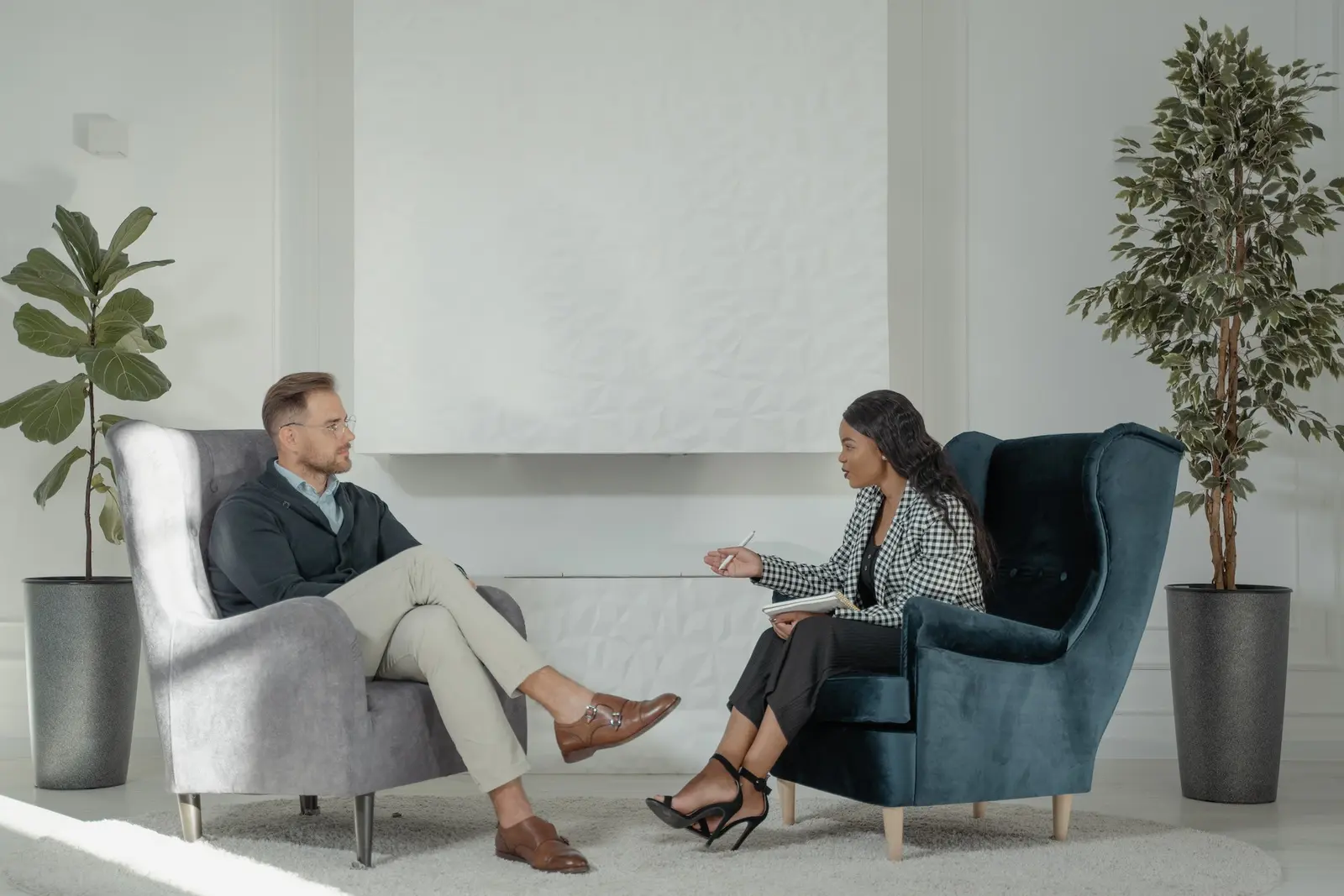 A therapist and client talking one-on-one in a bright room