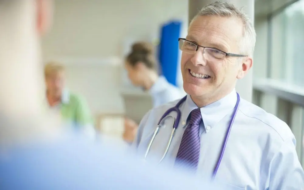 A physician in conversation with a colleague at a hospital