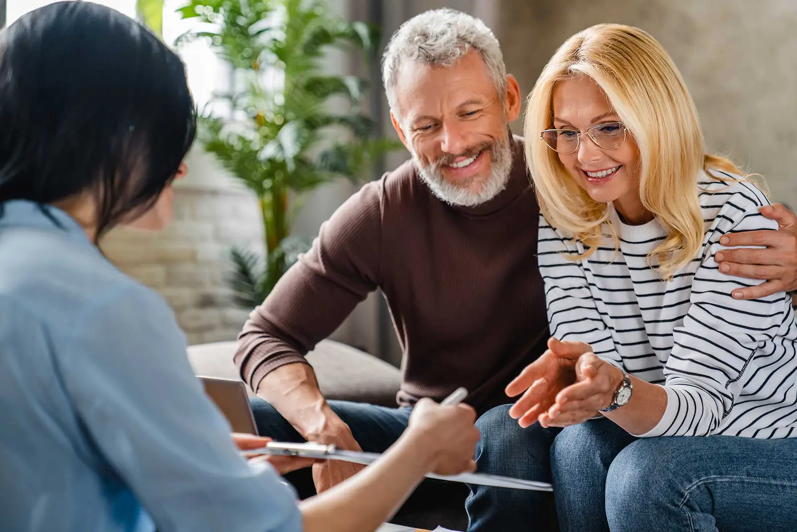 A couple sitting together while a counselor walks them through paperwork