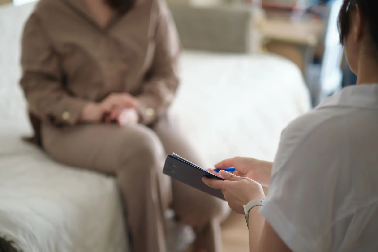 A therapist taking notes during a one-on-one CBT session