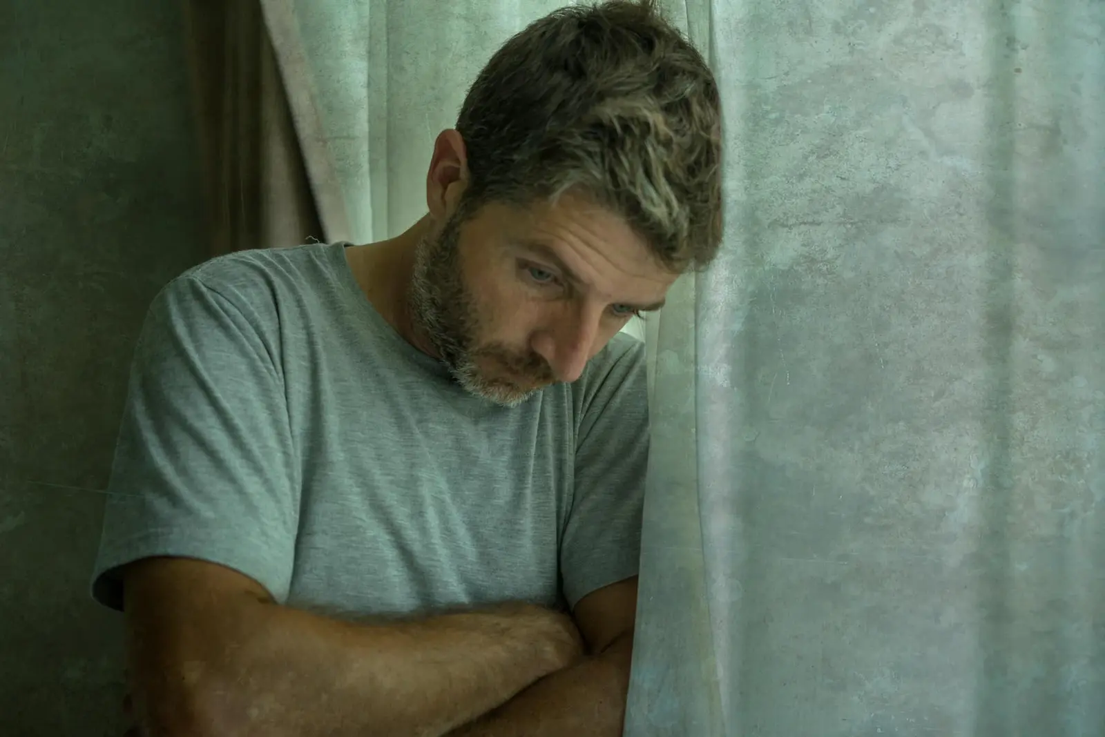 Man leaning against a window during a depressive episode