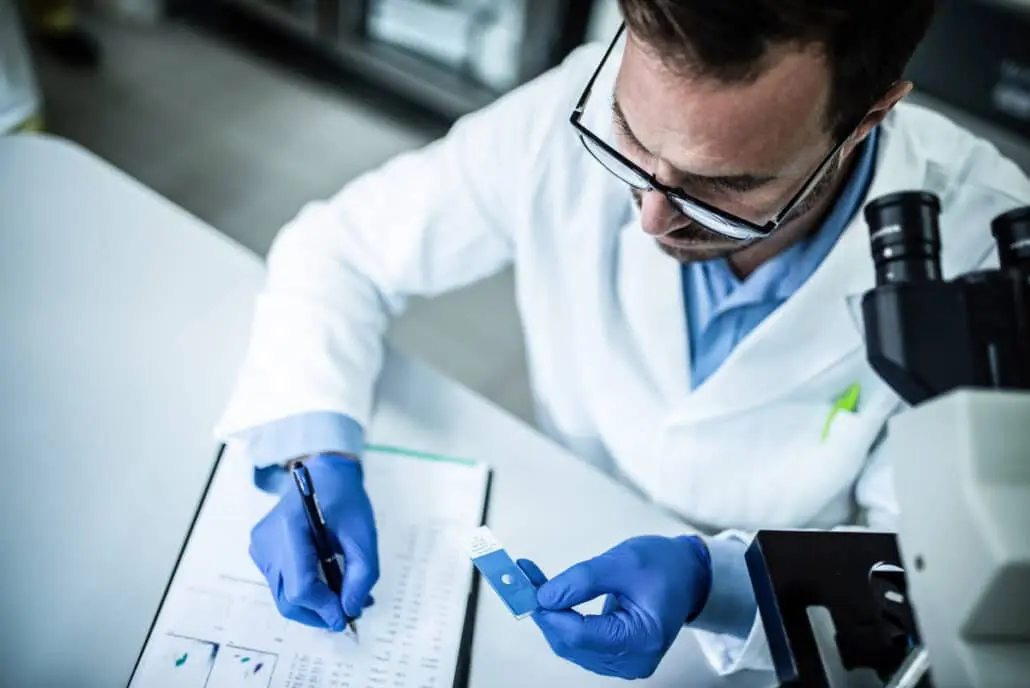 A lab clinician analyzes a genetic testing sample