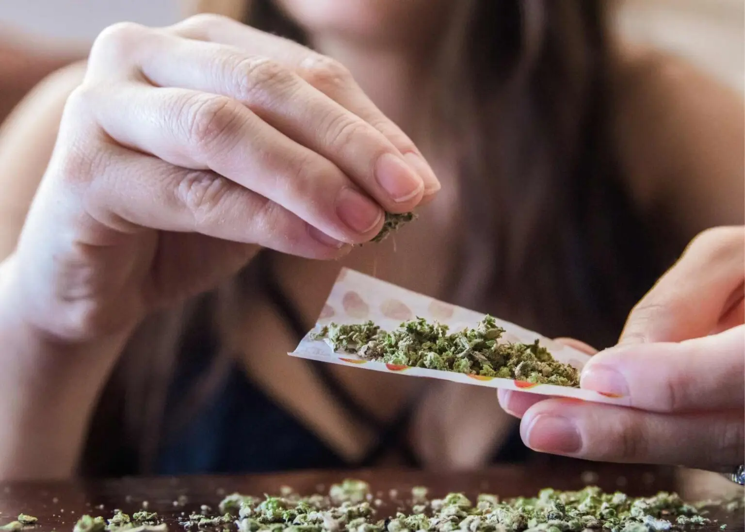 A person rolling marijuana before seeking weed detox