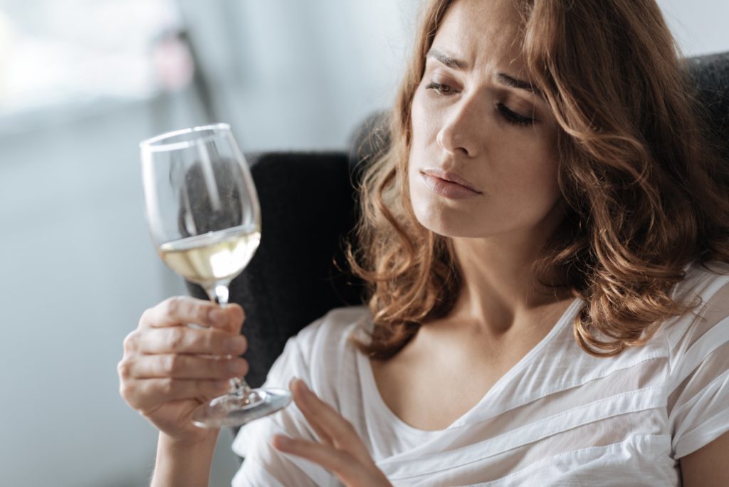 woman addicted to alcohol with a glass of wine